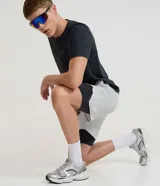 Bermuda deportiva verde militar con short de compresión incorporado, cintura elástica y cordón ajustable, confeccionada en microfibra de poliéster y elastano.