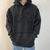 Canguro negro con capucha, corte oversize, con un diseño abstracto en el pecho.