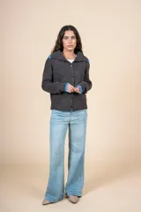 Cardigan de tejido con relieve en color gris oscuro, con cuello camisero y puños en contraste de color azul. Presenta cierre frontal con botones y un calce relajado.