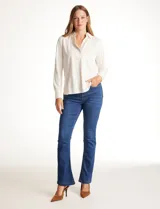 Remera de modal con cuello solapa, escote en V y cierre frontal con botones. Presenta mangas largas con puños elásticos y un corte recto con dobladillo ligeramente más largo en la parte posterior.