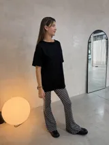 Remerón de corte oversized confeccionado en tela ribb, color negro, con cuello redondo, mangas cortas y tajos laterales en el ruedo.