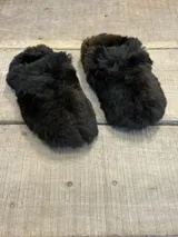 Pantuflas de estar por casa confeccionadas en piel sintética de pelo largo, con diseño cerrado y suela plana.