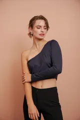 Top corto negro de un hombro con manga larga ajustada.