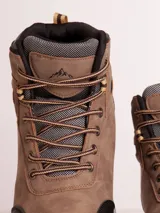 Botas de trekking color marrón con puntera reforzada en negro, suela gris y cordones marrones.