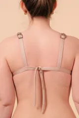 Top de bikini negro con vivos blancos, breteles regulables y nudo en la espalda.