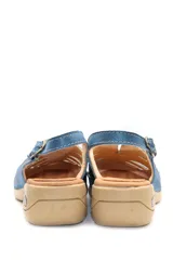 Sandalias bajas color beige con recortes geométricos en la capellada, tira trasera con hebilla ajustable y suela con cámara de aire.