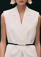 Chaleco tipo blazer sin mangas, de corte oversize y cuello con solapas. Confeccionado en lino, presenta un diseño abierto sin cierre y dos bolsillos laterales de ribete.