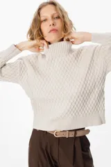 Sweater de tejido de punto con textura de panal, cuello alto y mangas largas. Presenta puños y ruedo acanalados.