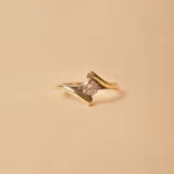 Anillo de diseño cruzado fabricado en plata 925 y oro, con una circonia central engastada y pequeños detalles de circonias laterales.