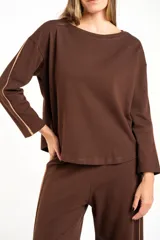 Sweater de manga larga color café, con textura gofrada y cuello redondo. Presenta una fina línea decorativa de color beige en el exterior de ambas mangas.