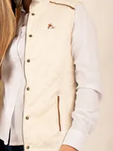 Chaleco beige capitoneado con cierre frontal y cuello alto.