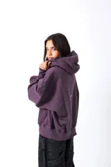 Hoodie color vino con capucha y bolsillo canguro frontal. Presenta un estampado en el pecho con la palabra "Outsider" en tipografía universitaria blanca con borde.