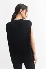 Chaleco negro de punto con cuello en V y sisas amplias.