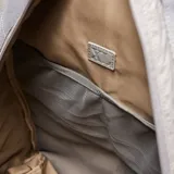 Mochila deportiva color gris, confeccionada en material textil con acabado arrugado. Presenta compartimento principal con cierre doble, bolsillo frontal con logo circular, compartimento inferior independiente para calzado y bolsillos laterales. Incluye tirantes ergonómicos ajustables y espaldera acolchada con malla transpirable.