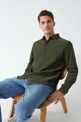Camisa de pana color verde militar, de corte regular, con cuello clásico y cierre frontal con botones.