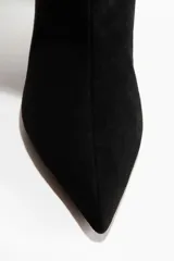 Botas de caña alta con diseño slouchy, confeccionadas en material con acabado cepillado suave. Presentan punta fina y taco kitten, con forro interior de punto.