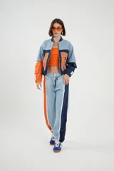 Pantalón de jean celeste de corte wide leg con bloques de color naranja y azul marino.