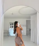 Minivestido con estampado animal print en tonos marrones, escote halter con abertura en el pecho y detalle de argolla metálica.