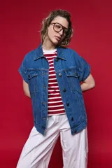 Chaleco de jean oversized color negro, con cuello camisero y cierre frontal con botones metálicos. Presenta un diseño estructurado con costuras reforzadas.