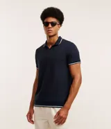 Remera polo blanca de viscosa texturizada con rayas, cuello y puños de mangas cortas en ribana con detalles contrastantes en negro.