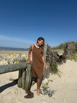 Vestido marrón de punto acanalado, corte recto, sin mangas, con cuello redondo y detalle de bordado en el pecho.