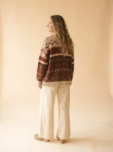 Cardigan de punto con diseño fair isle en tonos chocolate, ladrillo, naranja quemado y crema, de manga larga y escote en V.