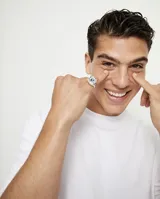 Anillo tipo sello plateado con forma de ojo y cristal facetado azul.