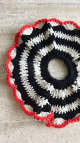 Colita de pelo tejida a crochet con hilo de algodón en color crema y borgoña, con borde rosa.