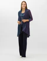 Conjunto de tres piezas compuesto por una musculosa recta, un cardigan liviano de frente abierto con mangas 3/4 y un pantalón de seda fría. La musculosa y el cardigan están confeccionados en tejido plisado con hilos metalizados tornasolados. Incluye collar removible y forro interno a tono.