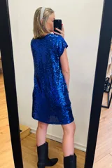 Vestido corto azul eléctrico cubierto de lentejuelas, con escote en V y mangas cortas amplias.