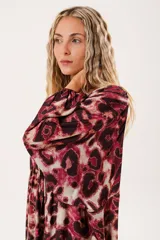 Vestido midi con estampado animal print en tonos borgoña y beige, con escote redondo y abertura en el pecho que se ajusta con lazos finos. De silueta relajada, manga larga tipo globo con terminación fruncida y falda amplia con recortes.