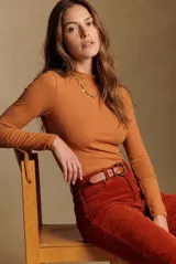 Polera de morley color ocre, de calce ajustado al cuerpo, con cuello alto y mangas largas.