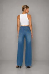 Jean de tiro alto con lavado celeste clásico y silueta wide leg. Presenta un diseño de cinco bolsillos, cierre frontal con botón y cremallera, y un corte recto y relajado que se extiende desde la cadera hasta el ruedo.