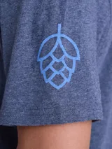 Remera de algodón color azul jaspeado, con cuello redondo, manga corta y estampado pequeño en el pecho.
