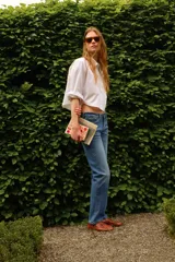 Jean de denim azul con corte slim regular, tiro medio, cinco bolsillos y cierre con cremallera y botón.