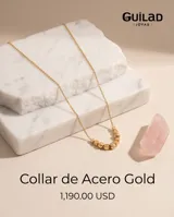 Collar de cadena fina con baño de oro, adornado con una serie de pequeñas esferas y un cubo central.