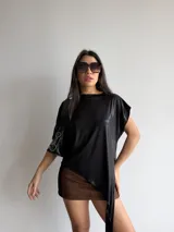 Top asimétrico negro de tul brillante elastizado, con diseño de corte irregular y caída en punta.
