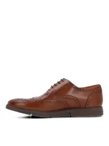 Zapato tipo Oxford estilo brogue color marrón, con detalles de perforaciones decorativas en la puntera y laterales. Cuenta con cierre de cordones y suela de goma con diseño deportivo.
