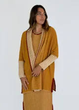 Saco abierto color mostaza con mangas 3/4 y detalle de rayas horizontales en puños y solapa.