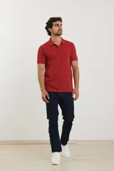 Polo de piqué color rojo, manga corta, con cuello y tapeta de botones al tono.