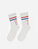 Par de medias blancas con rayas horizontales azules y rojas en el borde superior. Cada media tiene una frase bordada en color rojo.