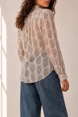 Camisa de manga larga color beige con estampado geométrico y floral en tonos marrones y naranjas, escote en V y botonadura frontal.