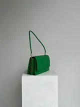 Cartera verde con textura símil piel de serpiente, para usar al hombro, con doble compartimiento interno, dije de marca metálico y cerramiento con broche imán.