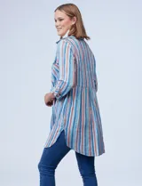 Camisola estampada a rayas verticales en tonos celeste, azul, naranja y marrón. Cuello con solapa, abertura central con botones y bolsillo aplicado en el pecho. Mangas largas regulables con presilla y botón. Laterales con bolsillos en costura. Marca Ruby Rd.