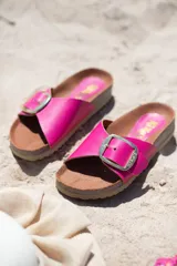 Sandalias de cuero color marrón con hebilla metálica plateada.