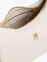 Cartera Tommy Hilfiger de poliuretano color beige, con cierre superior de cremallera, asa corta y correa extraíble. Cuenta con el monograma metálico de la marca en el frente.
