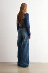 Pantalón de jean wide leg en color blanco, de tiro alto y corte ancho con dobladillo ancho en los bajos.