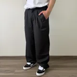 Pantalón de vestir negro de corte ancho, con pinzas en el delantero y elástico en la cintura trasera.