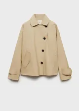 Campera color beige, tipo anorak, con cuello camisero, cierre frontal con botones, manga larga con trabillas, diseño oversize y forro interior.