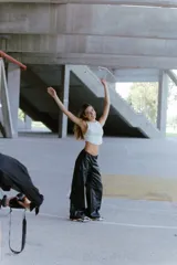 Pantalón cargo de ecocuero negro, de corte holgado y tiro medio-alto. Presenta bolsillos laterales tipo cargo y costuras visibles a lo largo de las piernas.